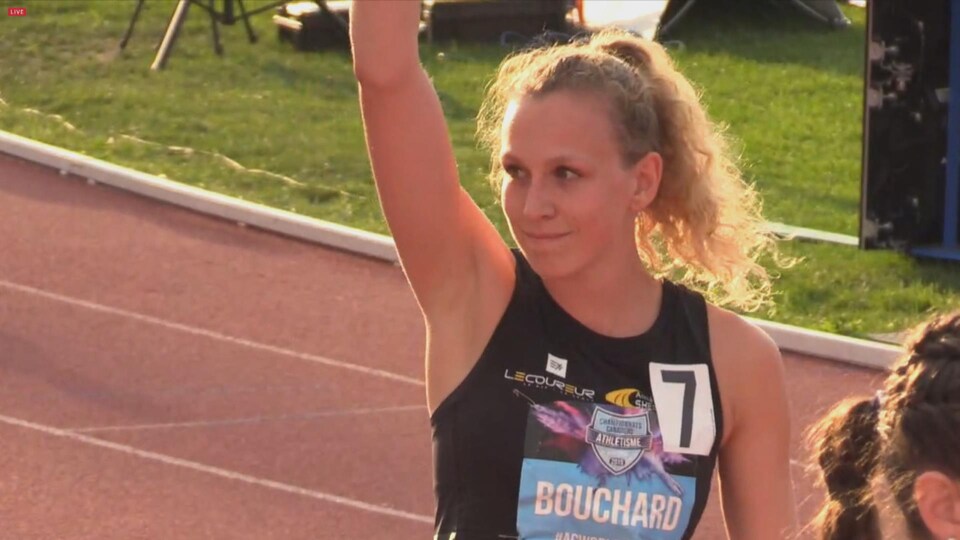 Elle lève un bras avant sa course.
