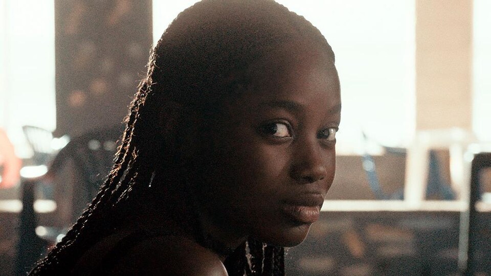 Une adolescente regarde vers la caméra.