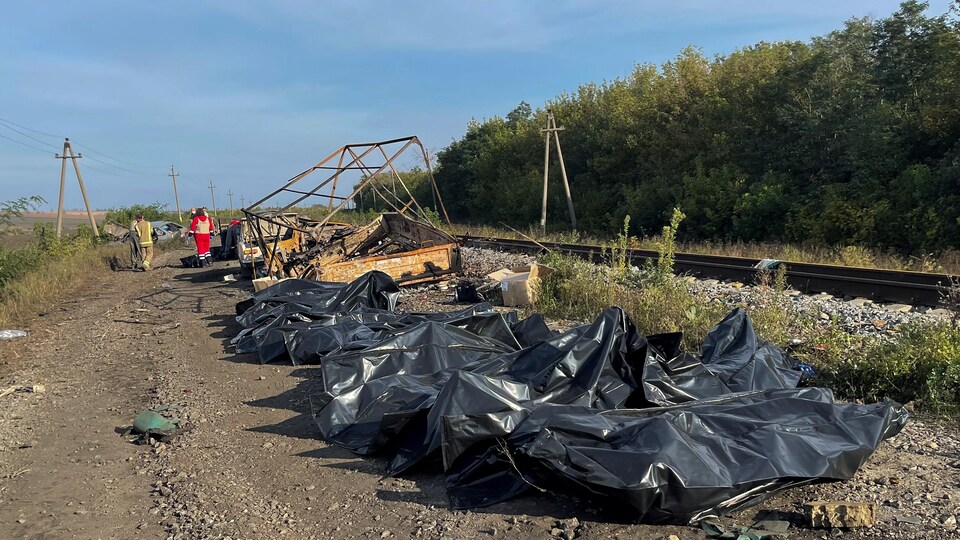 Des cadavres dans des sacs de plastique sur le bord d'un chemin de fer. 