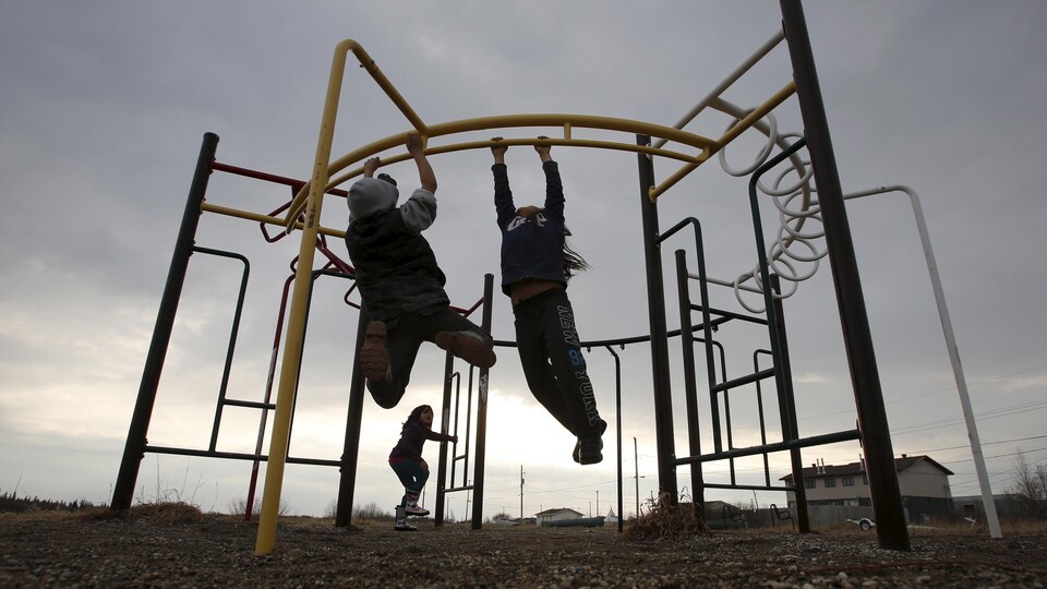 Des enfants jouent dans un parc situé dans la communauté d'Attawapiskat, dans le Nord de l'Ontario.