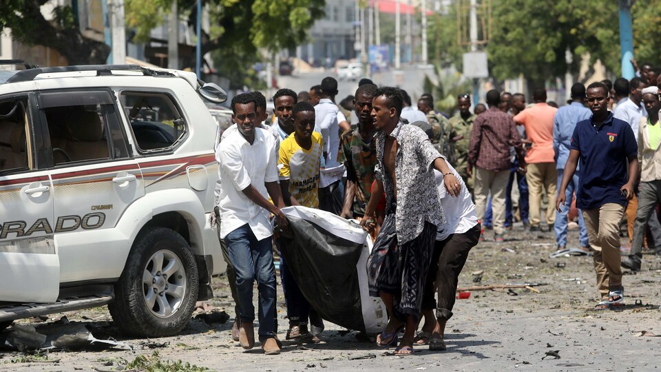 Des hommes transportant une victime d'un attentat.