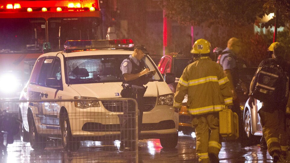 Des policiers et des pompiers sous la pluie.