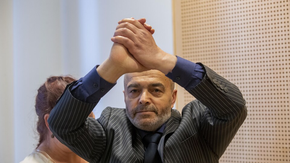 Le suspect Walid Abdulrahman Abu Zayed lève ses mains jointes au-dessus de sa tête au cours d'une comparution au tribunal d'Oslo, en Norvège.