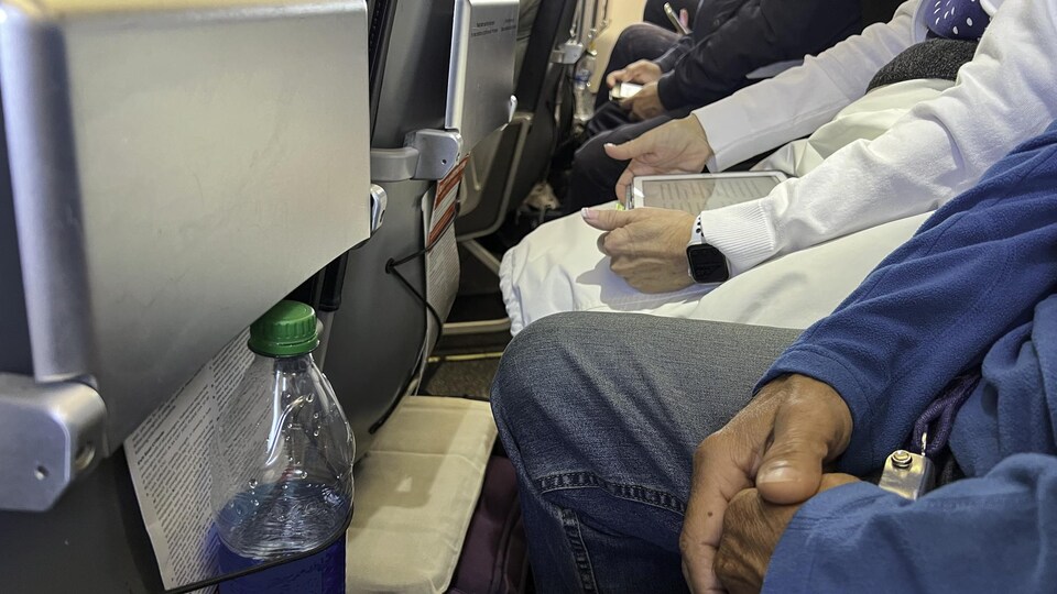 Des passagers assis très près les uns des autres, avec très peu d'espace pour les jambes.