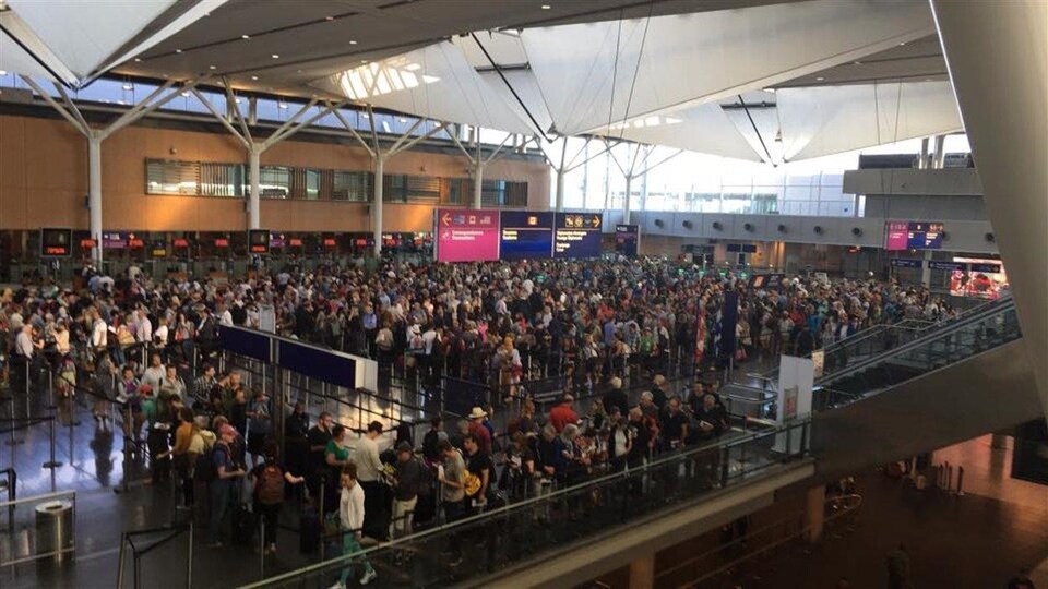 Des voyageurs attendent aux douanes de l'aéroport Montréal-Trudeau.