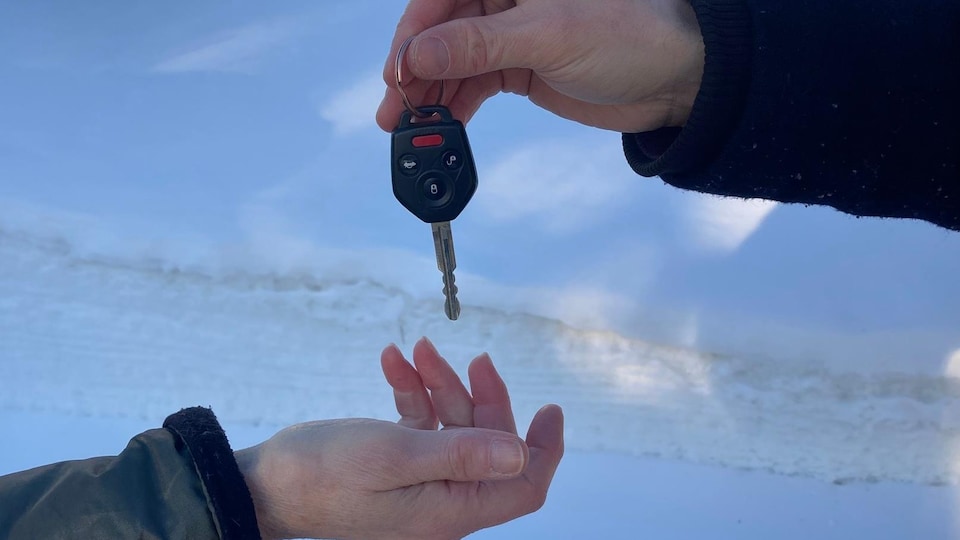 Un homme donne sa clé de voiture à une femme.