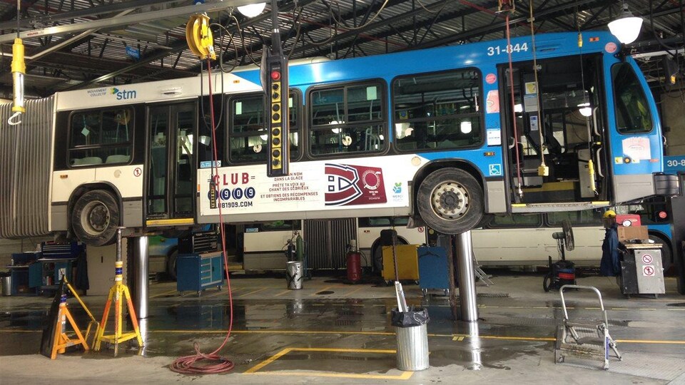 Un autobus en réparation dans un garage de la STM.