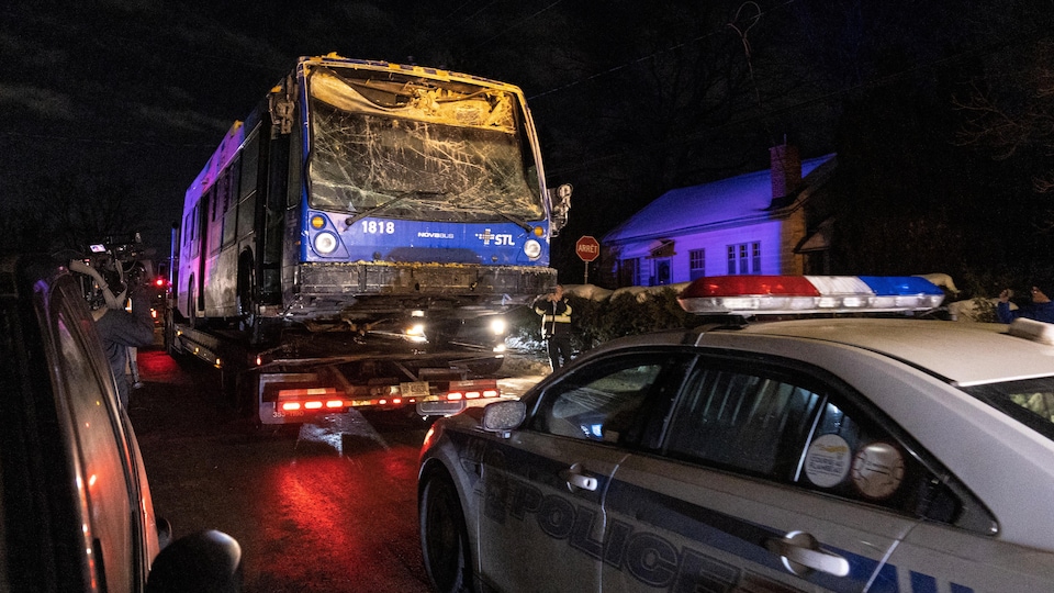 Un autobus se fait remorquer la nuit en hiver. 