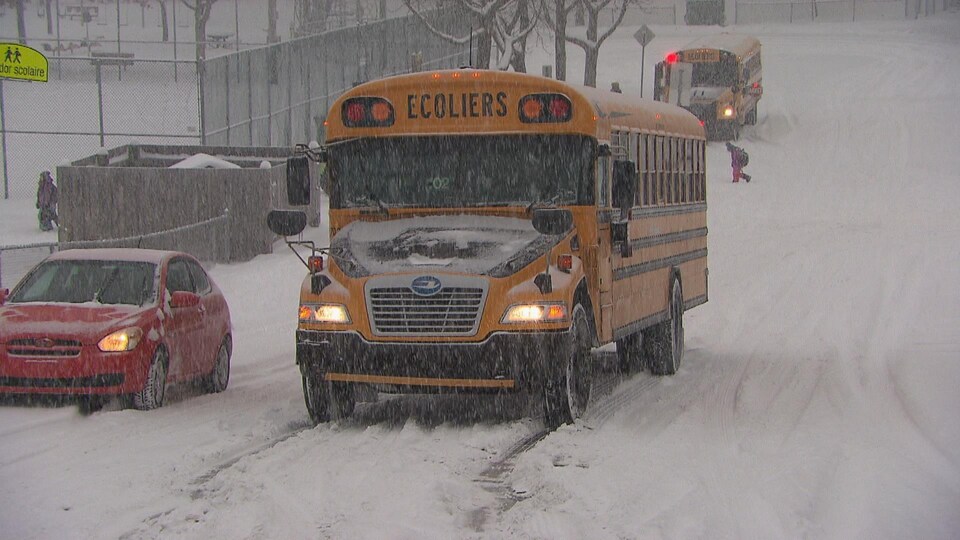 Un autobus scolaire sur une route enneigée. 
