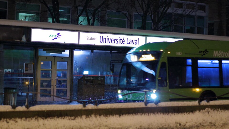 Un autobus est arrêté à la station Université Laval, un soir d'hiver.