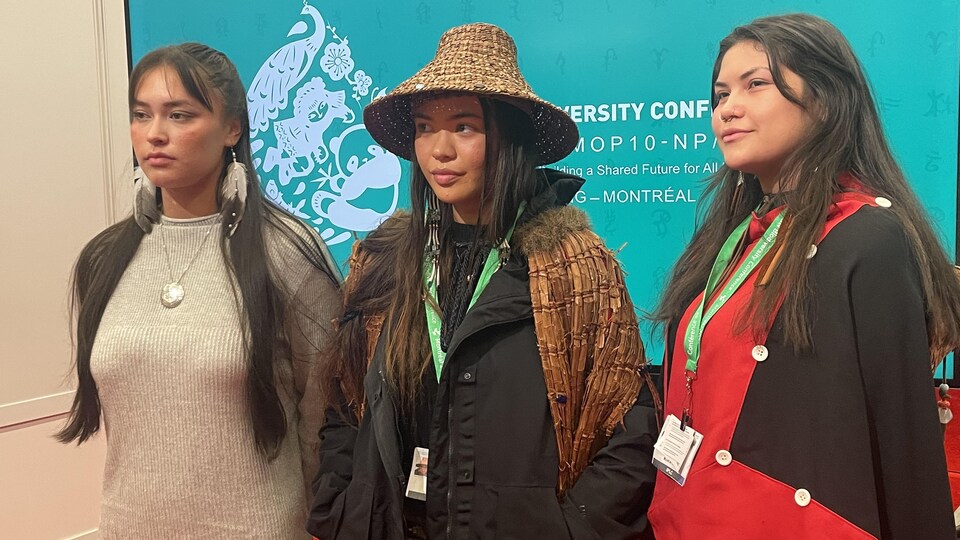 Vienna Timothy, Ta'kaiya Blaney et Ace Harry devant un panneau de la COP15.