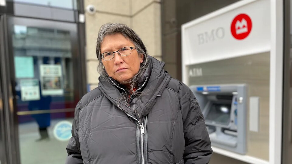 Une femme devant la succursale de la Banque de Montréal.