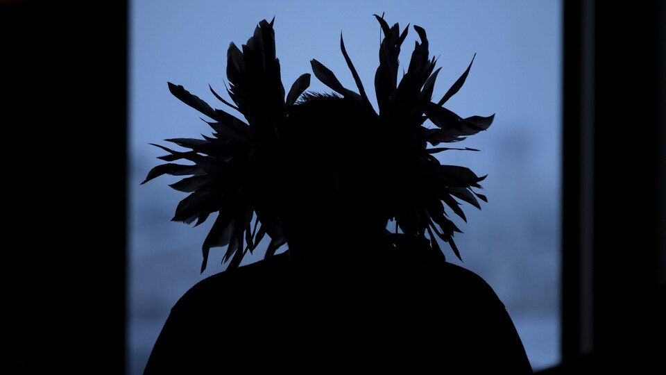 L'ombre d'un autochtone portant une coiffure traditionnelle est photographié lors d’une conférence de presse concernant la décision de la Cour d’appel fédérale de rejeter un appel de plusieurs Premières Nations contre l’expansion du pipeline Trans Moutain à Vancouver, en Colombie-Britannique, le mardi 4 février 2020.