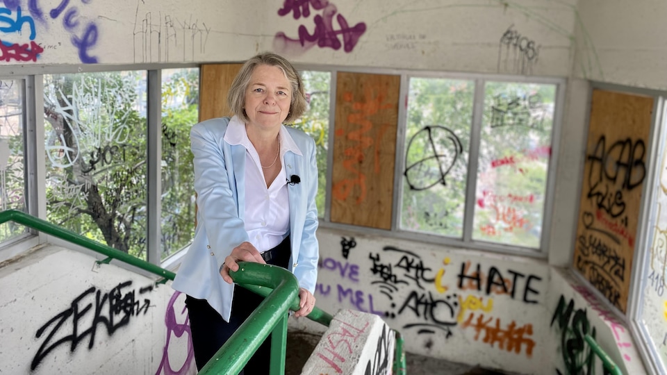 Une femme dans une cage d'escalier remplie de graffitis.