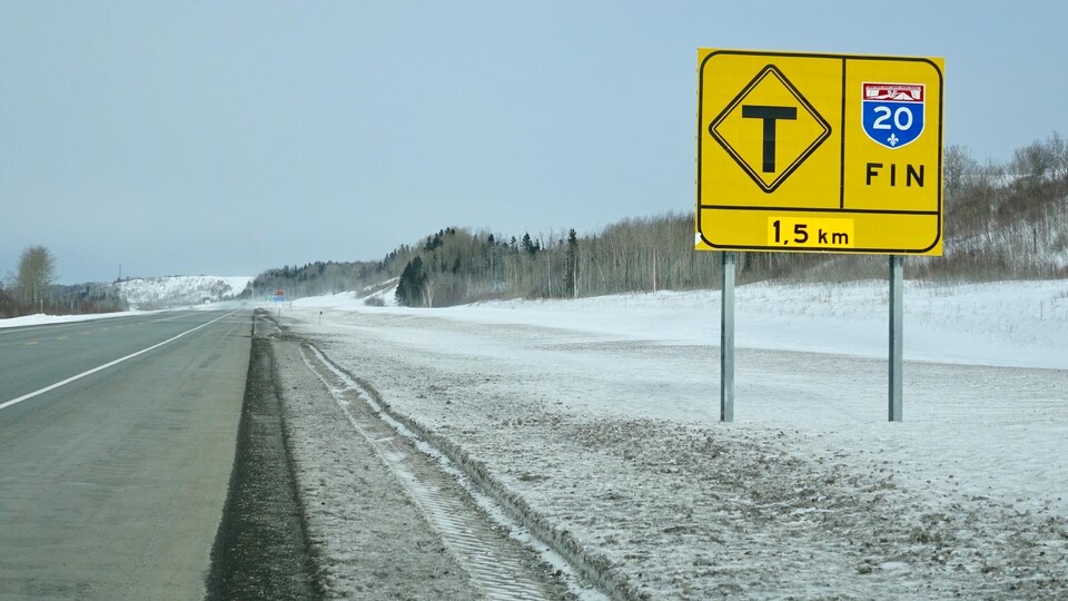 Un panneau de signalisation annonce la fin de l'autoroute 20 sur une route enneigée.