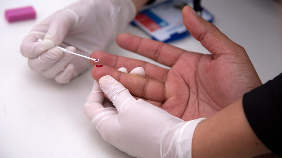 Un homme effectue un test rapide de dépistage du VIH.