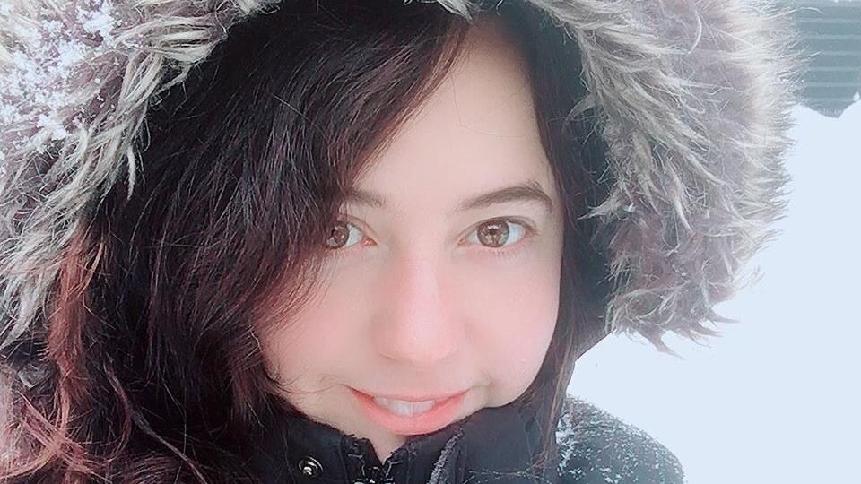 Une femme fait un sourire à la caméra.
