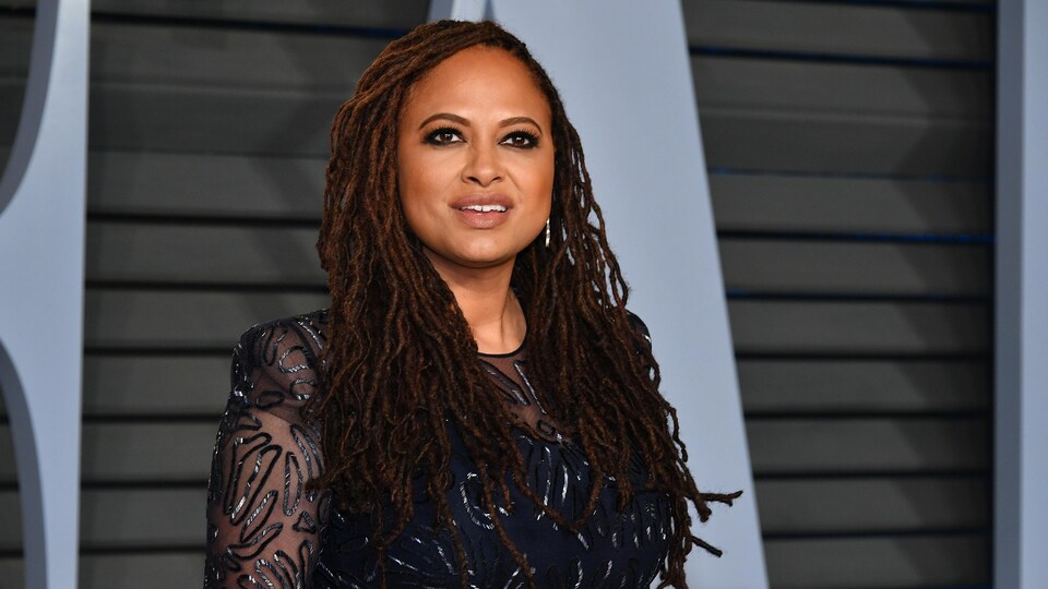 La réalisatrice et productrice Ava DuVernay, vêtue d'une robe bleu nuit, prend la pose sur le tapis rouge de la fête organisée par le magazine Vanity Fair après la cérémonie des Oscars.
