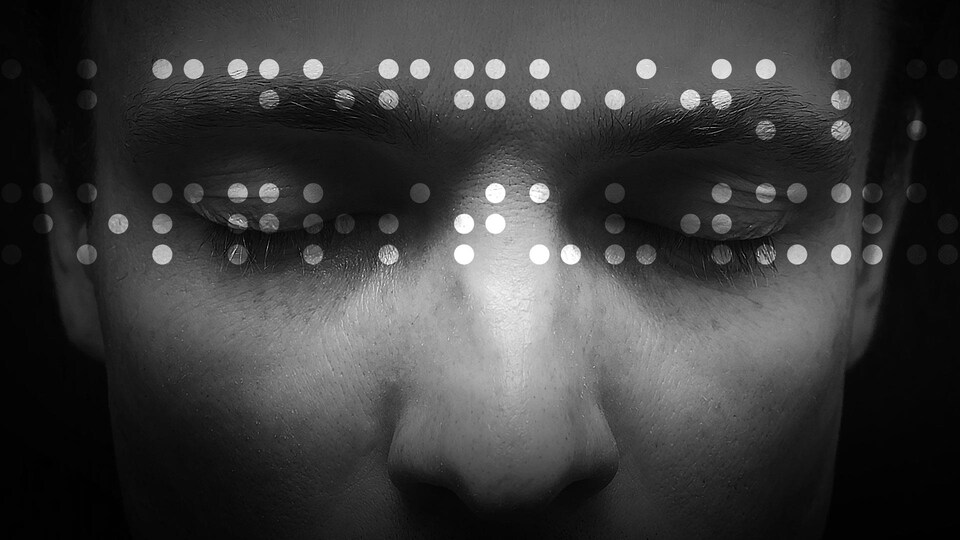 Une photo en noir et blanc d'une personne qui a les yeux fermés.
