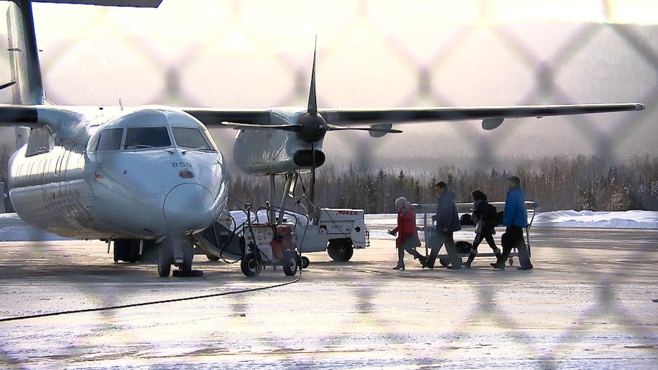 Passagers qui embarquent dans un avion à l'aéroport de Gaspé.