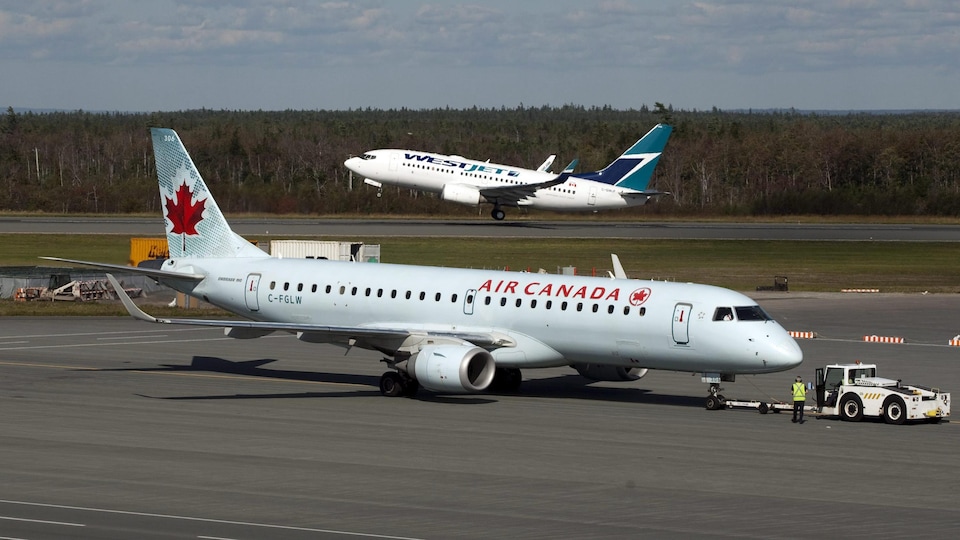 Deux avions d'Air Canada et de WestJet sur le tarmac.