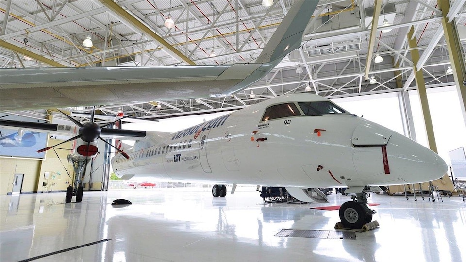 Un appareil Q400 de Bombardier à l'intérieur d'un hangar.