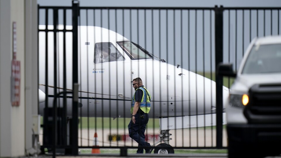 Un employé de l'aéroport passe devant l'avion.
