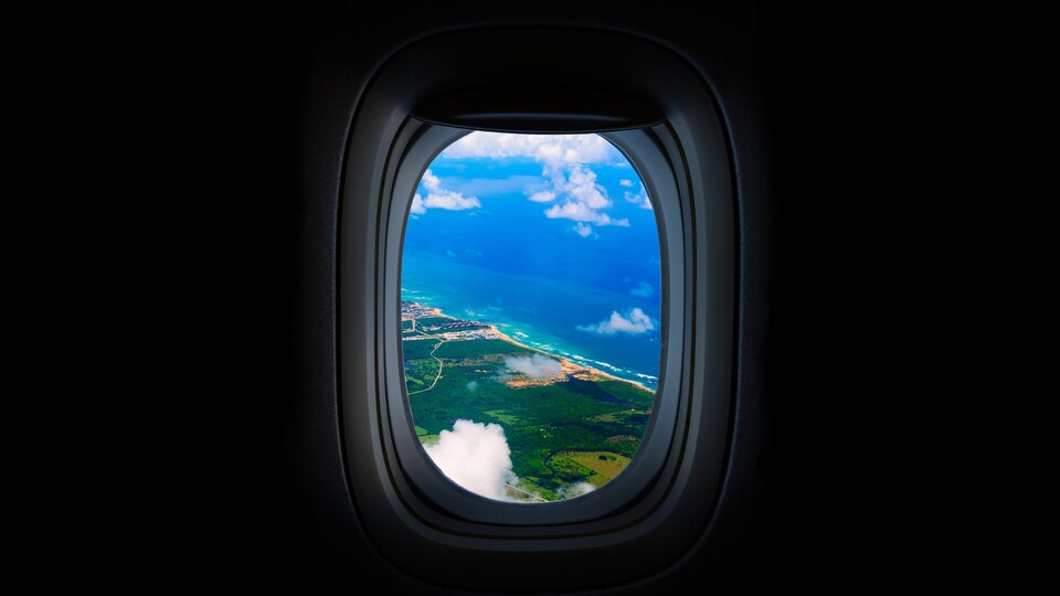 Une plage visible du hublot d'un avion.