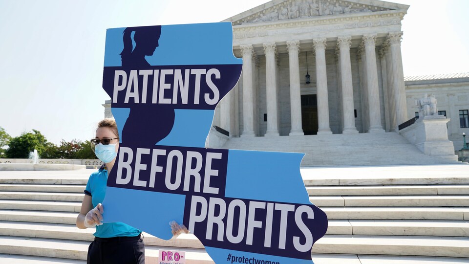 An anti-abortion protester holds a poster that reads: ‘Patients before profits’.