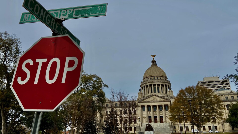 Un panneau de signalisation 'Stop" est en avant plan du Capitole du Mississisippi.