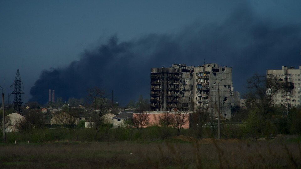 Smoke rises from an industrial area after shelling.