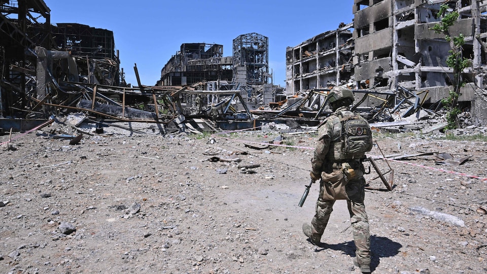 Un soldat marche dans les ruines de l'usine.