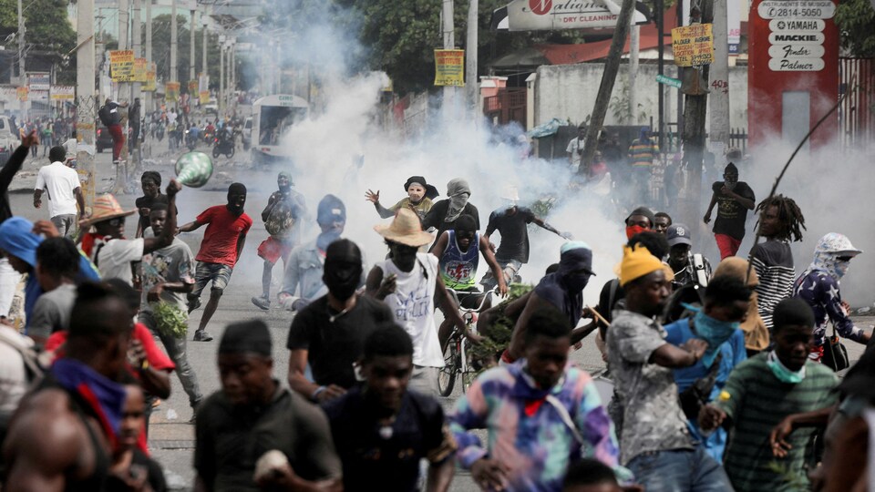 Des manifestants fuient des tirs de gaz lacrymogènes lancés par les forces de l'ordre. 
