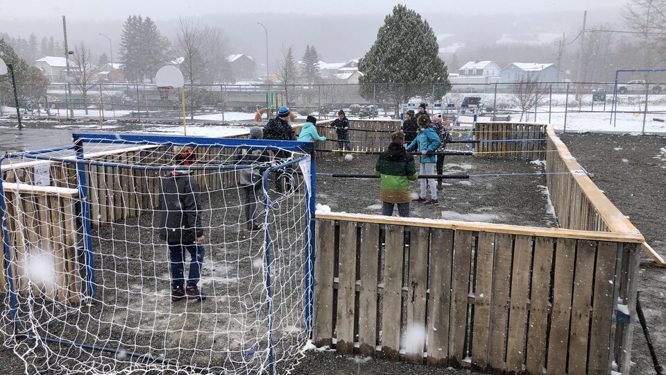 Des élèves s'amusent dans le jeu de soccer sur table géant.