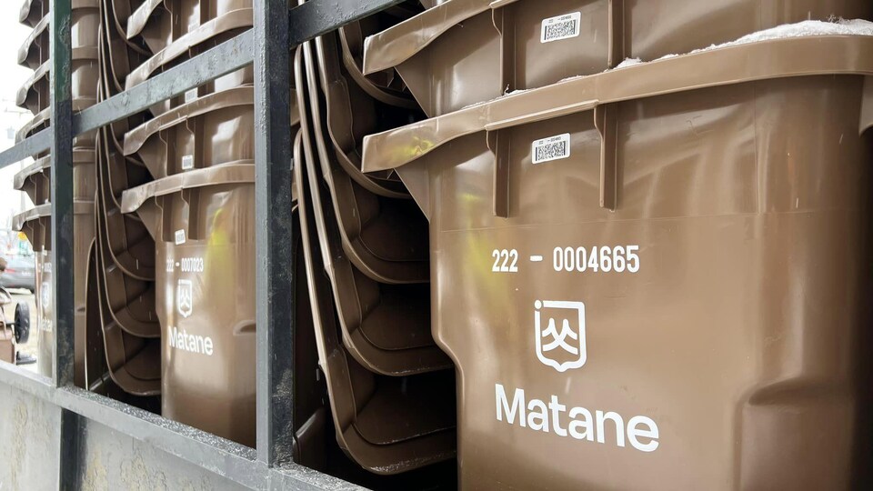 Des bacs à compost sont empilés à l'arrière d'un camion.