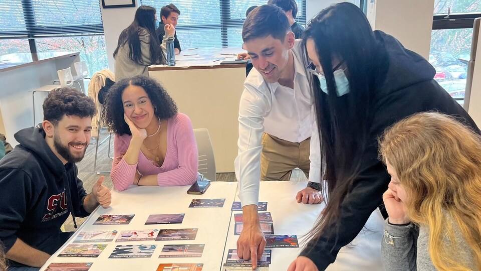 Des étudiants assis à une table devant des images.