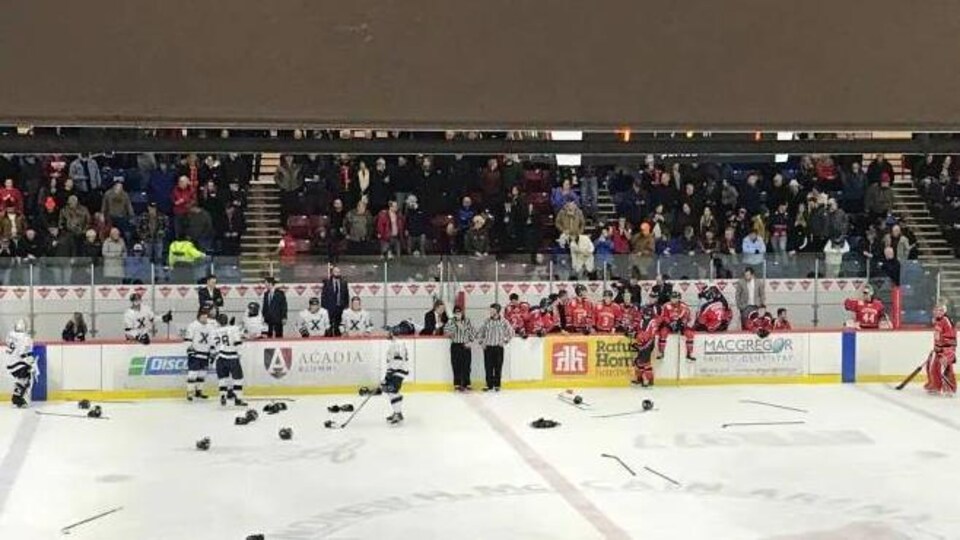 Les bancs de Acadia et Saint-Francis-Xavier après la bagarre générale. Beaucoup de gants et de bâtons sont sur la glace (archives.)