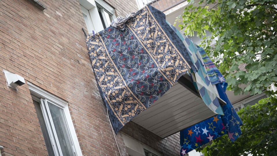 Un balcon est entouré de draps colorés pour le rendre plus privé.