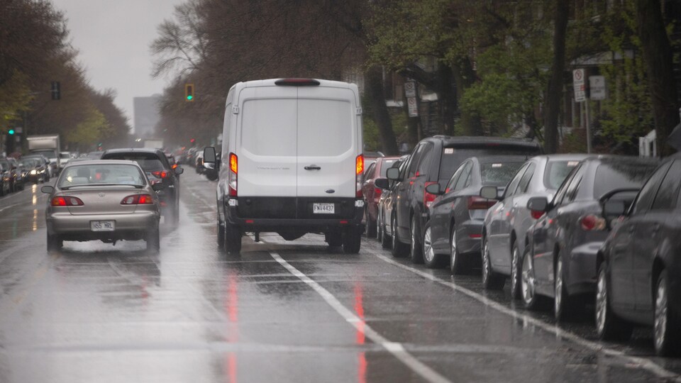 Une camionnette blanche garée sur une bande cyclable.