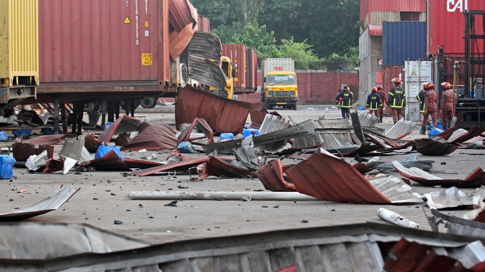 Firefighters were walking through debris at the scene of the fire followed by an explosion in a container warehouse.