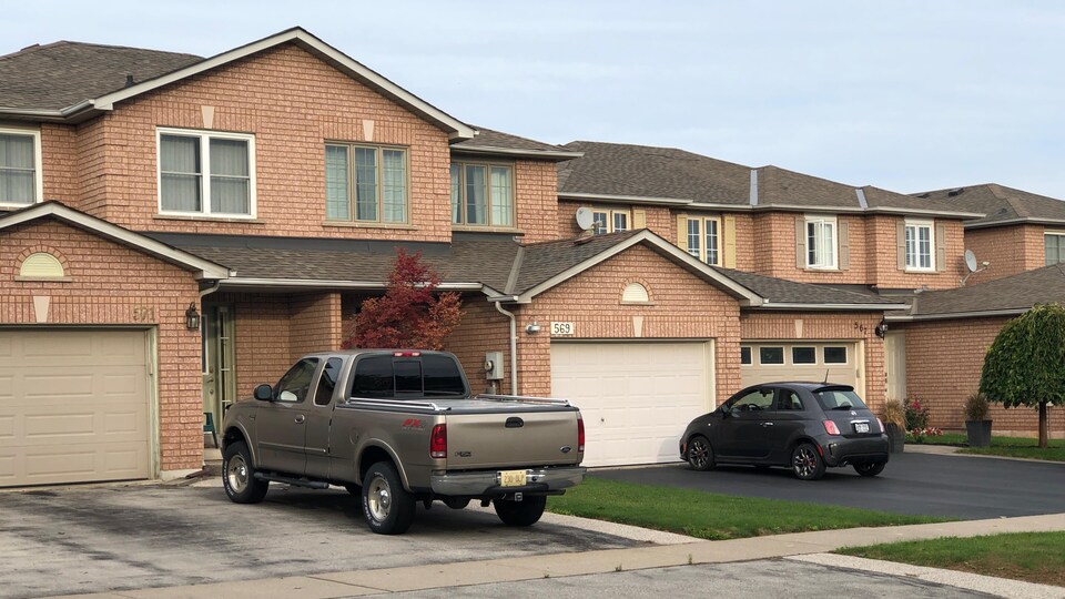 Des maisons en rangée à Burlington, en banlieue de Toronto, avec des voitures devant.