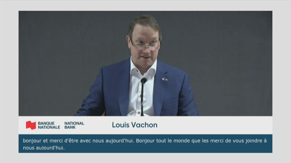 Louis Vachon donnant une conférence sur un écran.