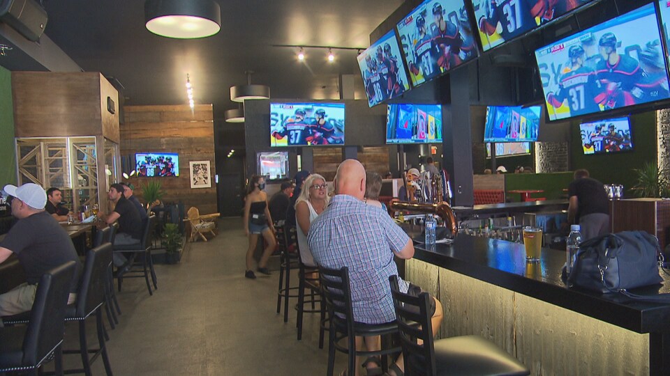 L'intérieur d'un bar avec des écrans de télévision.