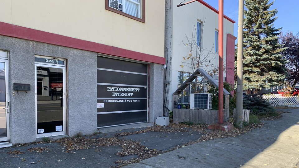 Une porte de garage où est inscrit Stationnement interdit.