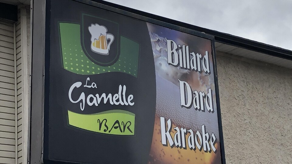 Enseigne du bar La Gamelle sur laquelle sont écrits les mots billard, dard et karaoké.