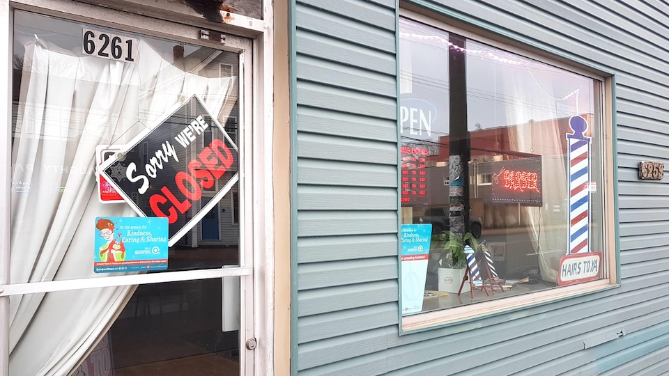 Affiche dans la porte d'un salon de barbier annonçant que l'endroit est fermé.
