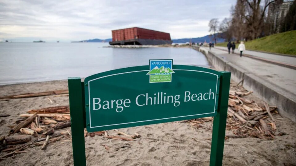 Un panneau qui indique « Barge Chilling Beach » avec une barge en fond.
