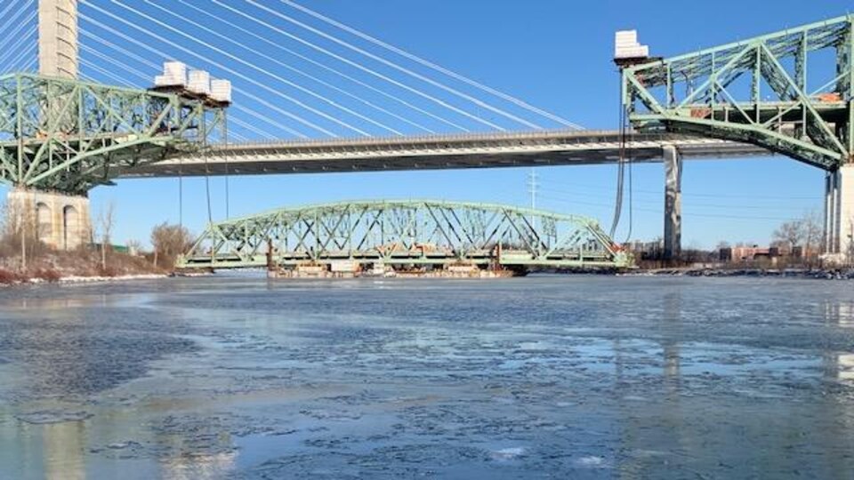 Partie centrale du pont Champlain chargée sur la barge, sur le fleuve.