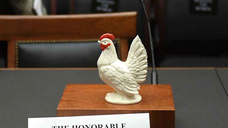 Un élu démocrate a posé la figurine d'un poulet sur le bureau devant la chaise, vide, où devait s'asseoir William Barr. On voit aussi son nom.