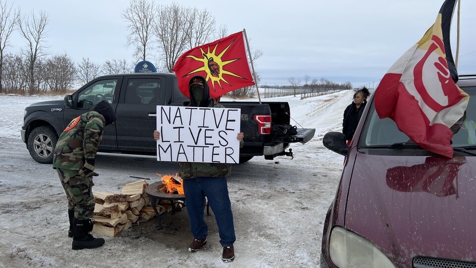 Des voitures et des personnes. Sur une pancarte, il est écrit en anglais : "Native lives matter", soit "La vie des Autochtones compte". 